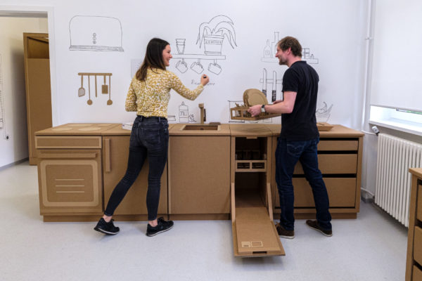 Im Innovation Hub kann die häusliche Situation bei pflegebedürftigen Menschen mit original-großen Möbeln, Küchengeräten und Sanitäranlagen aus Pappe abgebildet werden. (Bildquelle: Uni Halle/Maike Glöckner)
